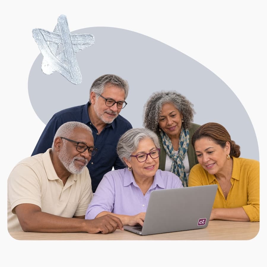Un grupo de personas mayores sonríe frente a una laptop